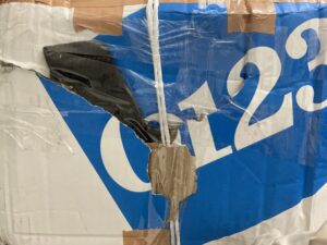 国際郵便で届いた、破れて補強されているダンボールの写真です